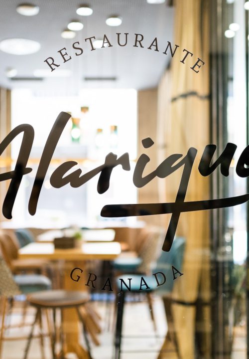 Fotografía de restaurante Alarique Granada - Entrada con logo en cristal y sala interior